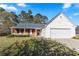 Charming single-story home with brick accents, a covered porch, and a two-car garage at 704 Manor Ridge Dr, Loganville, GA 30052