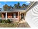 Close-up of the brick front porch featuring a charming front door and white railing at 704 Manor Ridge Dr, Loganville, GA 30052