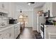 Eat-in kitchen boasts white cabinets and appliances and a ceiling fan at 704 Manor Ridge Dr, Loganville, GA 30052