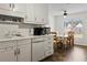 Eat-in kitchen with white cabinets and tile backsplash has lots of natural light at 704 Manor Ridge Dr, Loganville, GA 30052