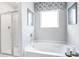 Bright bathroom featuring a glass enclosed shower and a soaking tub beneath a window with decorative valence at 12106 Conrad Cir, Hampton, GA 30228