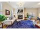 Comfortable living room featuring a stone fireplace, white sofa with blue pillows, and large rug at 4224 Gateland Ave, Marietta, GA 30062