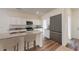 Modern kitchen with granite countertops, stainless steel appliances, an island with bar stools and wood flooring at 2399 Argento Cir, Dacula, GA 30019