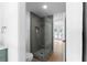 Modern bathroom featuring a glass shower, gray tile, and gold fixtures at 3336 Myrtle St, Atlanta, GA 30354