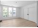 A bright, minimalist bedroom with three windows and large closet doors at 3336 Myrtle St, Atlanta, GA 30354