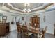 Stylish dining room featuring elegant tray ceilings, a wooden dining table, and a view of the kitchen at 4803 Austin Hills Dr, Suwanee, GA 30024