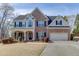 Charming two-story brick home with a well-manicured lawn and a two-car garage, showcasing curb appeal at 4803 Austin Hills Dr, Suwanee, GA 30024