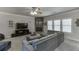 Cozy living room with stone fireplace, plush grey furniture, and large windows at 4803 Austin Hills Dr, Suwanee, GA 30024