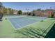 View of community tennis courts with green and blue surface in a wooded area at 4803 Austin Hills Dr, Suwanee, GA 30024