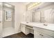 Bright bathroom with dual sink vanity, white cabinetry, and a large mirror with Hollywood-style lighting at 5110 Montcalm Sw Dr, Atlanta, GA 30331