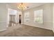 Bright dining room featuring large windows, a modern chandelier, and carpeted flooring perfect for entertaining at 5110 Montcalm Sw Dr, Atlanta, GA 30331