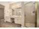 Bright main bathroom featuring double sinks, shower stall, and large mirror illuminated by decorative lighting at 5110 Montcalm Sw Dr, Atlanta, GA 30331
