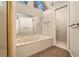 Light-filled main bathroom featuring a large soaking tub, shower and private water closet at 5110 Montcalm Sw Dr, Atlanta, GA 30331