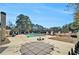 Community pool area with mature trees, fencing, plenty of lounging space, and a picnic table at 5110 Montcalm Sw Dr, Atlanta, GA 30331