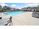 A community pool with sun loungers and chairs is surrounded by residential buildings and lush landscaping at 117 Villanueva Rd, Woodstock, GA 30188