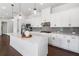 Modern kitchen features white cabinets, a large island, herringbone backsplash, and updated appliances at 117 Villanueva Rd, Woodstock, GA 30188