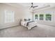 Spacious main bedroom featuring a tray ceiling with a ceiling fan and multiple windows at 117 Villanueva Rd, Woodstock, GA 30188