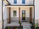 Inviting front porch with brick accents and sturdy wooden support columns at 117 Villanueva Rd, Woodstock, GA 30188