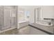 Well-lit bathroom with a glass-enclosed shower, a soaking tub, and double sink vanity at 12098 Conrad Cir, Hampton, GA 30228