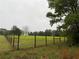 Fenced pasture area on a rainy day provides seclusion for this property at 12421 Highway 36, Covington, GA 30014