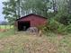 Detached garage with a partially open bay, showcasing storage and project potential at 12421 Highway 36, Covington, GA 30014