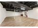 Finished basement with open ceiling, wood flooring, and ample storage space at 4135 Shoshone Valley Rd, Marietta, GA 30068