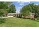 Charming brick home featuring a two-car garage, well-maintained lawn, and lush greenery at 4135 Shoshone Valley Rd, Marietta, GA 30068