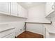 Practical laundry room with white cabinets, countertop space, and hardwood flooring at 4135 Shoshone Valley Rd, Marietta, GA 30068