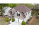 Aerial view of a charming brick home with a well-manicured lawn, two-car garage, and a private backyard at 1074 Frog Leap Nw Trl, Kennesaw, GA 30152
