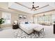 Bright bedroom featuring a tray ceiling, neutral walls, a seating area, and a cozy rug at 5124 Parkwood Oaks Ln, Smyrna, GA 30126