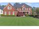 Handsome brick residence featuring an impeccable lawn, tasteful landscaping, and a covered entry offering classic charm at 5124 Parkwood Oaks Ln, Smyrna, GA 30126