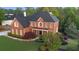 A brick two-story home with mature trees and lush bushes surrounding the property at 5124 Parkwood Oaks Ln, Smyrna, GA 30126
