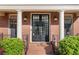 Close-up of the front door showcasing the black grid-pane doors, white columns, and a brick porch at 5124 Parkwood Oaks Ln, Smyrna, GA 30126