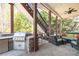Covered outdoor patio with built-in grill, seating, and a view of the lush backyard at 5124 Parkwood Oaks Ln, Smyrna, GA 30126