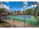 Tennis courts surrounded by a secure fence and lush trees for a private recreational experience at 5124 Parkwood Oaks Ln, Smyrna, GA 30126