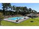 Community pool surrounded by lounge chairs, umbrellas, and mature trees, offering a relaxing and inviting outdoor space at 196 Silverton Dr, Dacula, GA 30019