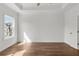 Bright bedroom features hardwood floors, a tray ceiling, and a large window for ample natural light at 2340 Edgar Park Pl # 97, Duluth, GA 30096