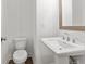 Small powder room featuring a pedestal sink, toilet and a wood-framed mirror at 2340 Edgar Park Pl # 97, Duluth, GA 30096