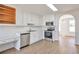 Clean kitchen with stainless appliances, light wood floors, white cabinets, and a built-in desk area at 4785 Beaver Rd, Loganville, GA 30052