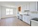 Bright kitchen with stainless steel appliances, light wood floors, and white cabinets at 4785 Beaver Rd, Loganville, GA 30052