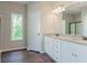 Bright bathroom featuring double vanity, granite countertop, and wood-look flooring at 490 Benson Meadows Dr, Dallas, GA 30157