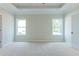 Spacious main bedroom with plush carpeting, two large windows, and tray ceilings at 490 Benson Meadows Dr, Dallas, GA 30157