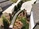Landscaped backyard with stone pathway, a retaining wall, and partial view of a modern house at 305 Red Gate Ln, Canton, GA 30115