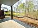 Backyard view from patio showing lush landscaping, a wooden fence, and stairs to upper deck at 305 Red Gate Ln, Canton, GA 30115