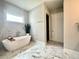 Stylish bathroom featuring a soaking tub, white marble tile, and modern fixtures at 305 Red Gate Ln, Canton, GA 30115