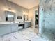 Bright bathroom featuring dual vanities, a makeup counter, and a walk-in shower with marble surround at 305 Red Gate Ln, Canton, GA 30115