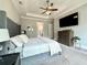 A relaxing bedroom features tray ceilings, a ceiling fan, and an entertainment center with TV at 305 Red Gate Ln, Canton, GA 30115