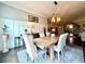 Open-concept dining room featuring a wood table, decorative rug, and wainscoting, illuminated by a modern chandelier at 305 Red Gate Ln, Canton, GA 30115