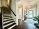 A bright and inviting foyer with stairs, decorative rug, elegant lighting, and hardwood flooring at 305 Red Gate Ln, Canton, GA 30115