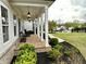 Inviting front porch featuring brick flooring and well-maintained landscaping, creating a welcoming entry at 305 Red Gate Ln, Canton, GA 30115